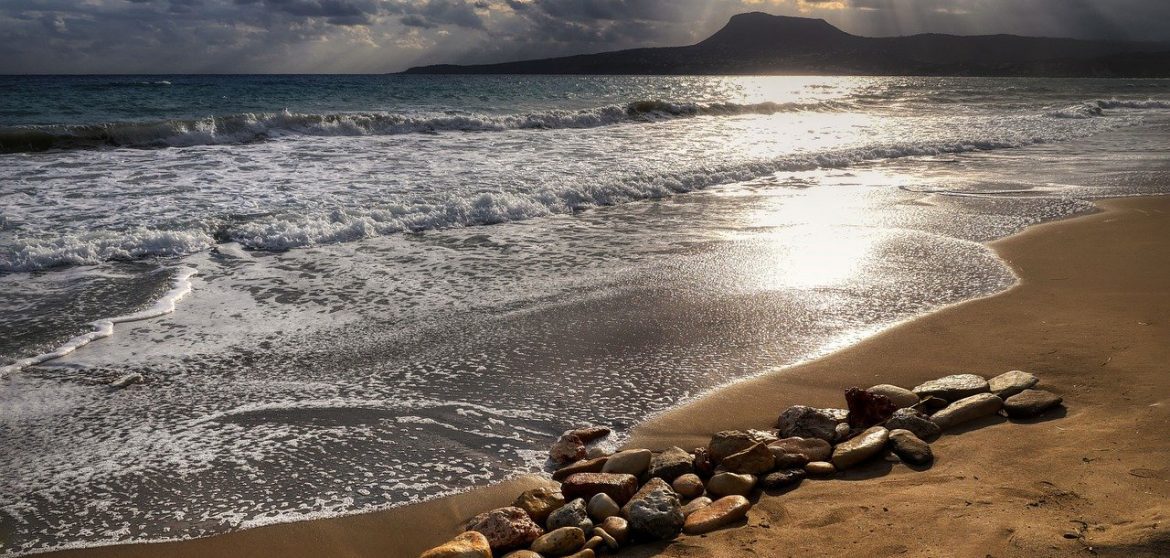 Crete sea coastline, sunset, water blue, sand.